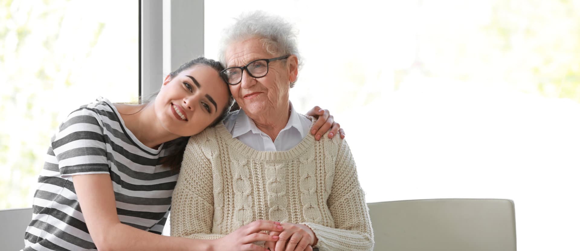 aide and elderly woman smiling at the camera