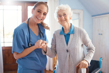 nurse and elderly woman smiling at the camera