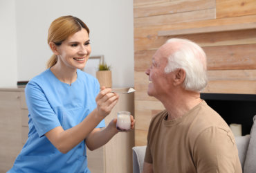 aide feeding an elderly man