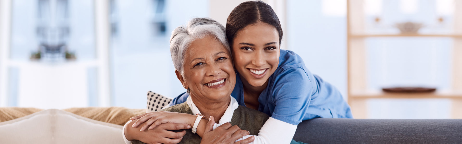 caregiver and elderly hugging