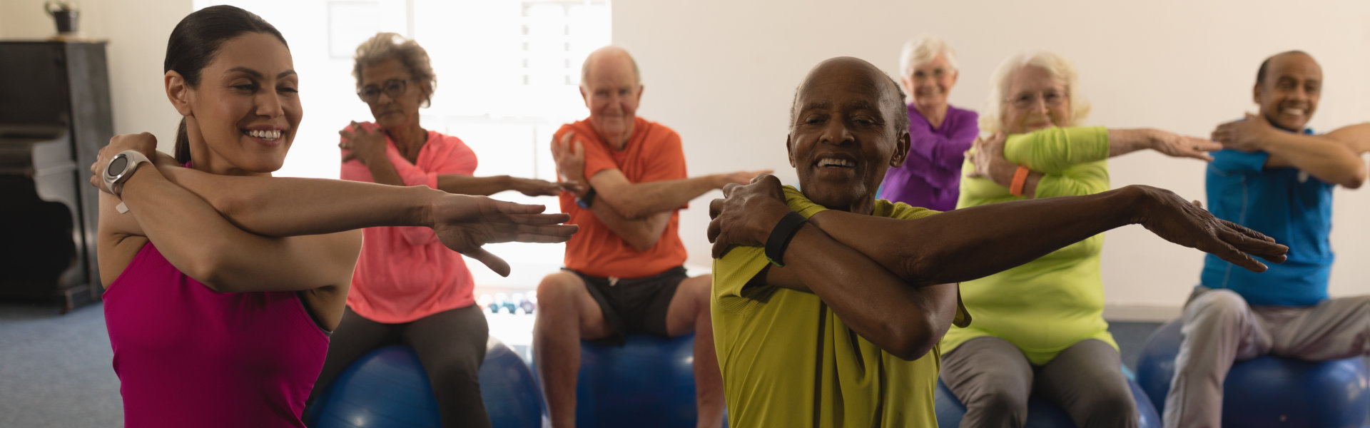 group of elderly having an exercise with caregiver