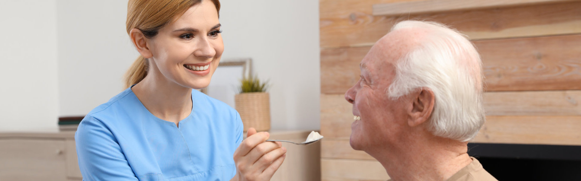 aide feeding an elderly man